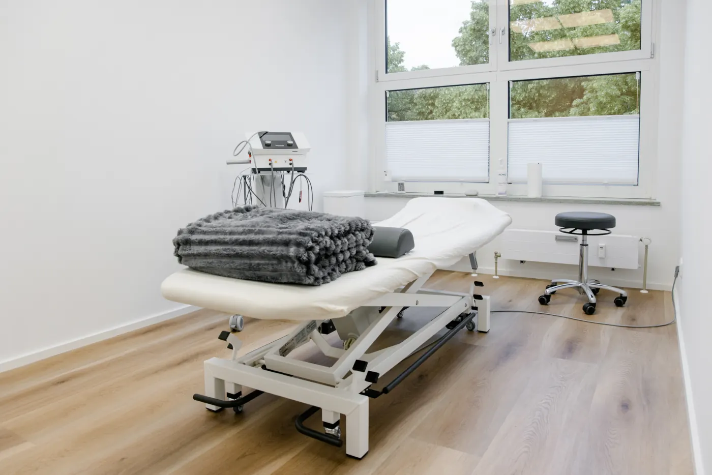 Behandlungsraum mit Therapieliege am Fenster
